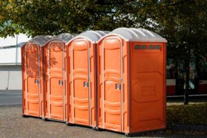 4 portable toilets in orange plastic